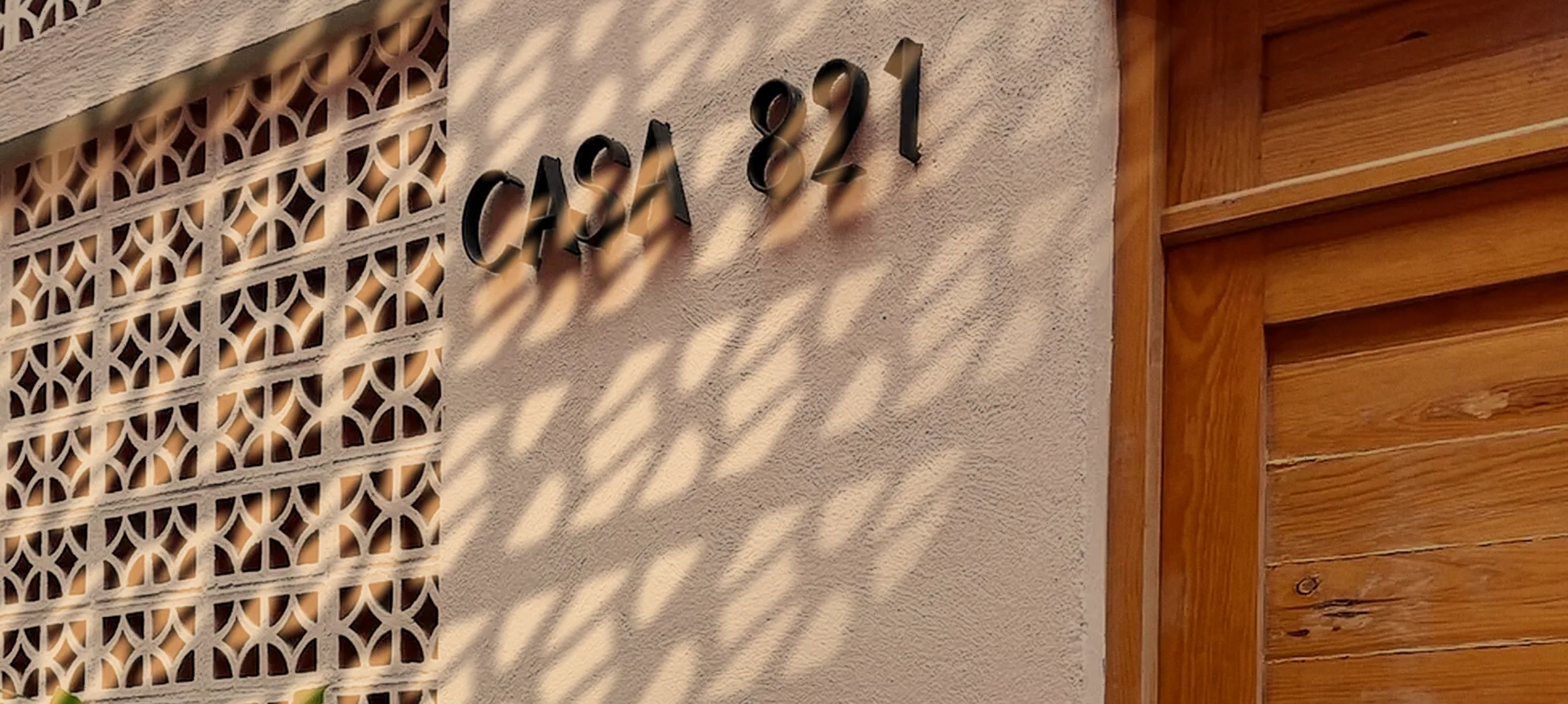 La luz de la tarde sobre el muro y el letrero de la entrada